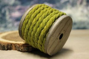 Žluto zelené světlé lanko na dřevěné špulce